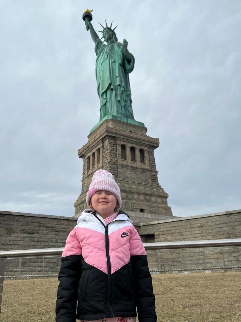 Child stood by the statue of liberty